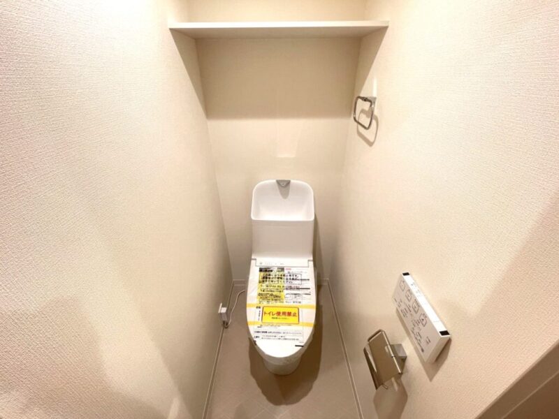 【トイレ】すっきりとしたデザインで清潔感があり、落ち着ける空間。トイレは温水洗浄機能付きです。吊棚も設置されており、トイレットペーパーなどが収納できます。