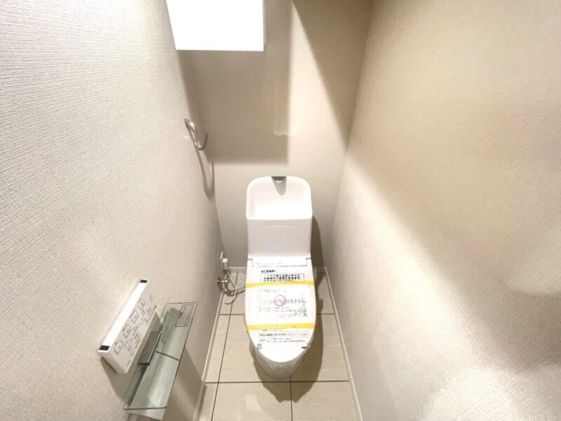 【トイレ】すっきりとしたデザインで清潔感があり、落ち着ける空間。トイレは温水洗浄機能付きです。吊戸棚も設置されており、トイレットペーパーなどが収納できます。