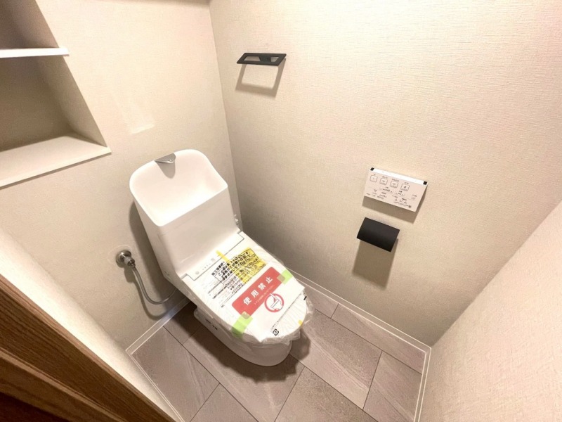 【トイレ】すっきりとしたデザインで清潔感があり、落ち着ける空間です。トイレもうれしい洗浄機能付きです。収納棚も設置されており、トイレットペーパーなどが収納できます。