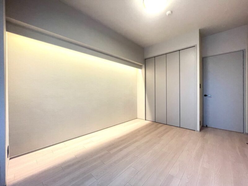 【主寝室:7.1帖】南西向きの窓からの採光が心地の良い洋室です。間接照明が安らぎの雰囲気を醸し出しています。間口が広く使い勝手の良いクローゼットを備え、大型ベッドが置ける広さで、主寝室におすすめです。