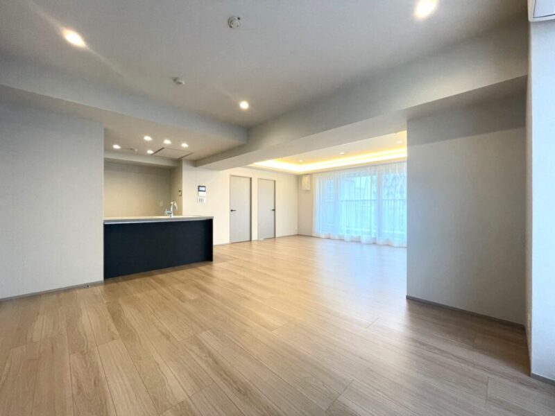 【LDK:約25.2帖】ホワイトを基調とした内装に、ダークカラーのキッチンがアクセントとなり、木目の美しいフローリングで、木のぬくもりを感じるナチュラルモダンな雰囲気のリビングダイニングとなっています。