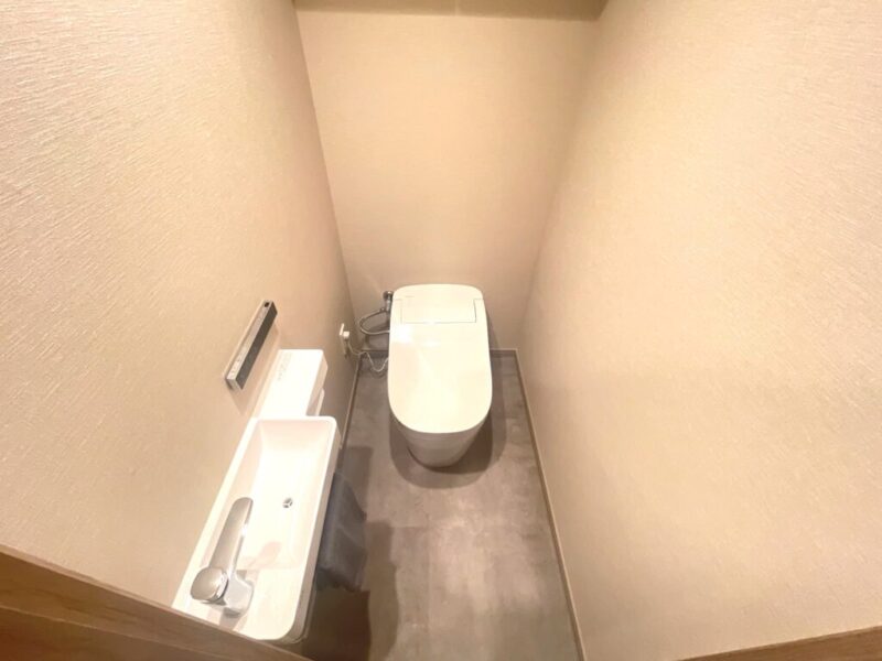 【トイレ】お手入れのしやすいタンクレスで、すっきりとしたデザインの温水洗浄機能付きトイレ。室内は清潔感があり落ち着く上質な空間です。便利な専用手洗いスペースも設けられています。