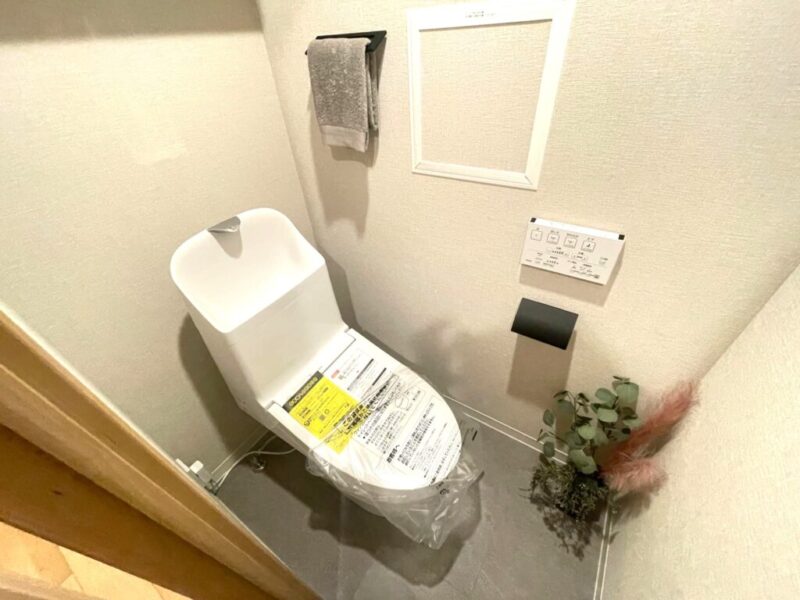 【トイレ】すっきりとしたデザインで清潔感があり、落ち着ける空間。トイレは温水洗浄機能付きです。吊戸棚も設置されており、トイレットペーパーなどが収納できます。