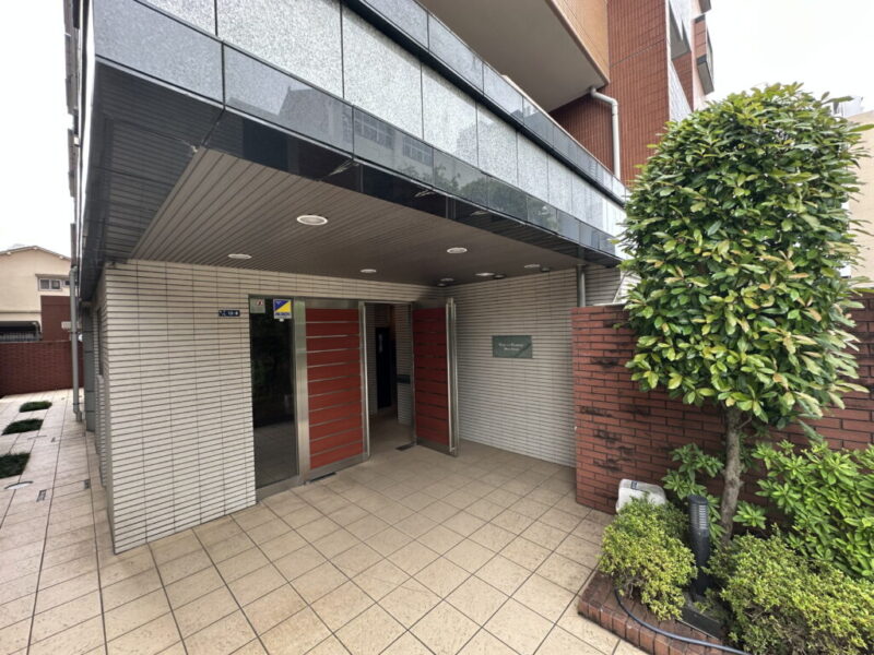 【エントランス】植栽を配したアプローチと洗練されたエントランスが、来訪者を上質に迎え、住まいの品格を感じさせます。オートロックや防犯カメラ、TVモニター付インターホンを採用。宅配ボックスも備え、不在時の荷物受け取りにも便利で安心です。