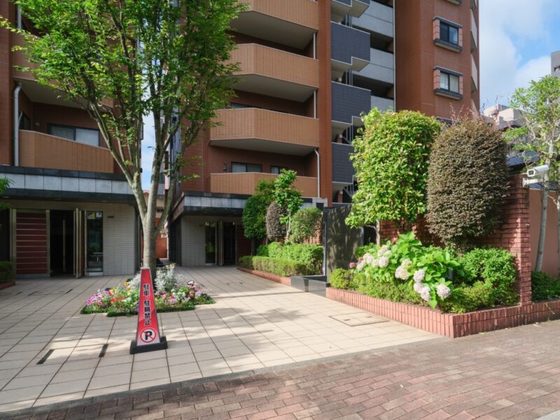 【エントランス】植栽を配したアプローチと洗練されたエントランスが、来訪者を上質に迎え、住まいの品格を感じさせます。オートロックや防犯カメラ、TVモニター付インターホンを採用。宅配ボックスも備え、不在時の荷物受け取りにも便利で安心です。