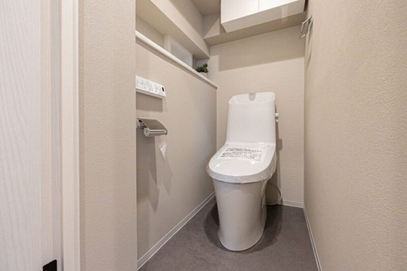 【トイレ】すっきりとしたデザインで清潔感があり、落ち着ける空間。トイレは温水洗浄機能付きです。吊戸棚も設置されており、トイレットペーパーなどが収納できます。