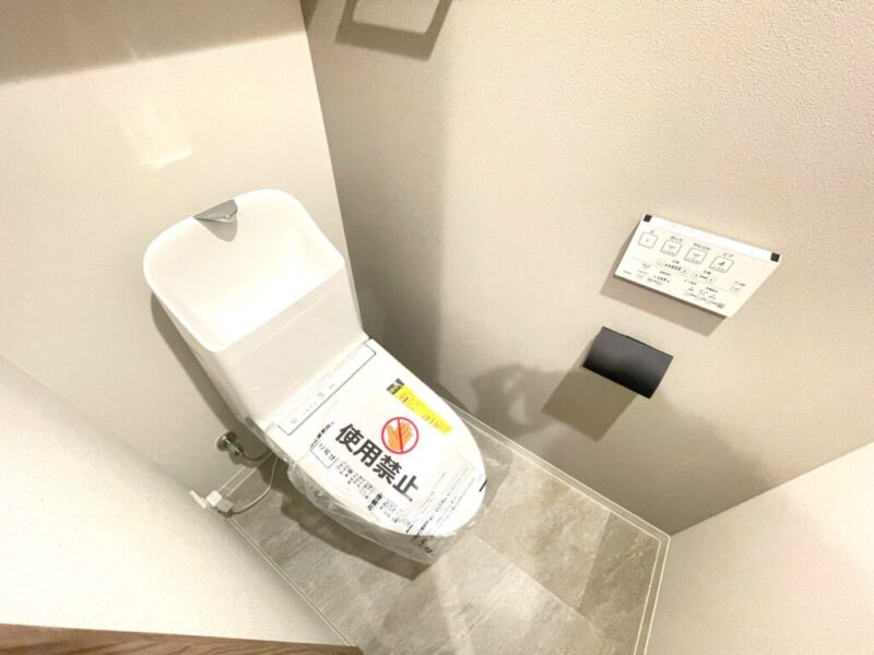 【トイレ】すっきりとしたデザインで清潔感があり、落ち着ける空間。トイレは温水洗浄機能付きです。吊戸棚も設置されており、トイレットペーパーなどが収納できます。