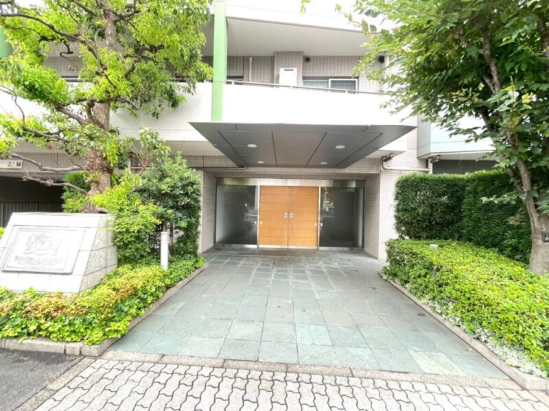 【エントランス】豊かな植栽に彩られたエントランスが住まいの品格を演出。ゆとりあるアプローチから、落ち着いた邸宅感を感じさせます。オートロックや防犯カメラ、防犯センサーなどを備え、日々の暮らしをしっかりサポート。宅配ボックスも設置され、留守中の荷物受け取りにも便利です。