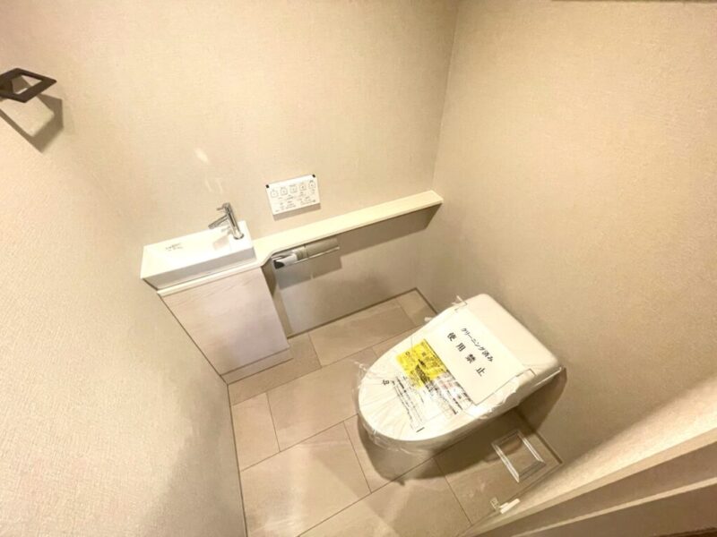 【トイレ】お手入れのしやすいタンクレスで、すっきりとしたデザインの温水洗浄機能付きトイレ。室内は清潔感があり落ち着く上質な空間です。カウンター付きの便利な専用手洗いスペースも設けられています。