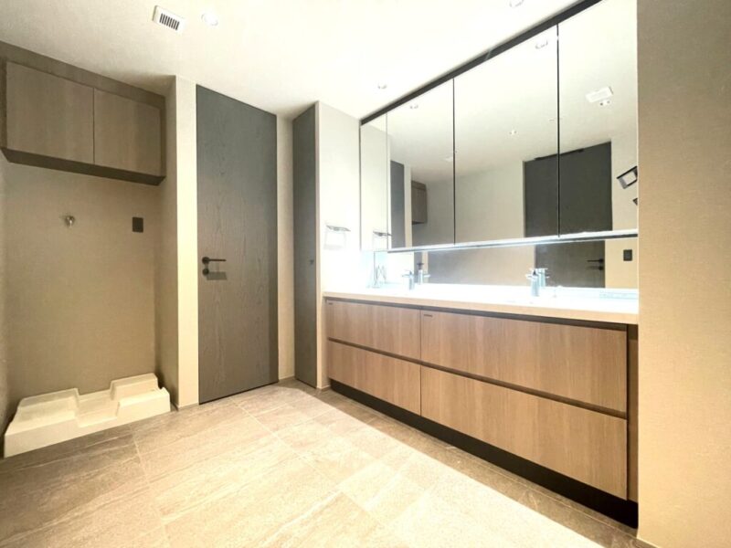【洗面室】洗練されたウッドデザインの洗面台は、便利なキャビネット付きのミラーで、シンク周りのスペースにもゆとりがあるので身支度もしやすく、シンク下にも収納を備え、スタイリッシュな見た目だけでなく使い勝手も良い仕様です。忙しい朝も家族並んで同時使いできる人気のダブルボウルです。