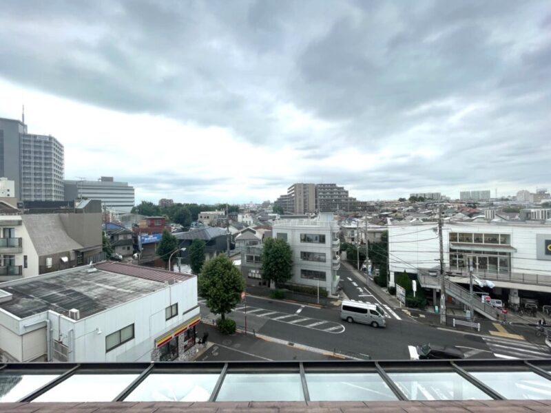 【住戸からの眺望】北西側は眼下はコンビニの駐車場や道路で、低層の建物が遠くの街まで抜けた開放感のある眺望です。