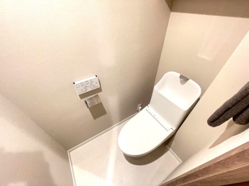 【トイレ】すっきりとしたデザインで清潔感があり、落ち着ける空間。トイレは温水洗浄機能付きです。吊戸棚も設置されており、トイレットペーパーなどが収納できます。
