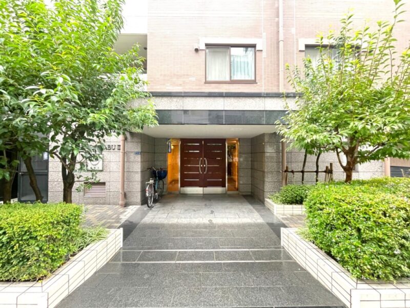 【エントランス】住まいへの期待感を高める、品格あるエントランスが迎えます。麻布十番という都心のロケーションにふさわしい落ち着いた雰囲気があり、日々の帰宅を心地よく演出してくれます。オートロックを採用したセキュリティ性に配慮された住まいです。TVモニター付インターホンで来訪者を確認できるほか、宅配ボックスや24時間ゴミ出しにも対応。都心でのスマートな暮らしを支えます。