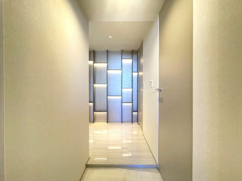 【玄関】表情のある間接照明が灯る飾り棚が演出する落ち着いた空間。玄関横にはシューズインクローゼットを備えています。シューズもたっぷり、ベビーカーや傘立ても収納でき、玄関フロアもすっきりご利用頂けます。