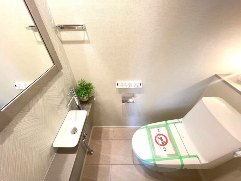 【トイレ】すっきりとしたデザインで清潔感があり、落ち着ける空間。トイレは温水洗浄機能付きです。カウンターとミラー付きの便利な専用手洗いスペースも設けられています。