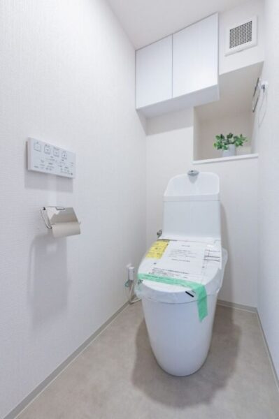 【トイレ】室内はホワイトを基調としていて清潔感があり、すっきりとした落ち着ける空間。トイレは温水洗浄機能付きです。吊戸棚も設置されており、トイレットペーパーなどが収納できます。