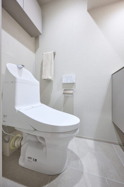 【トイレ】すっきりとしたデザインで清潔感があり、落ち着ける空間。トイレは温水洗浄機能付きです。吊戸棚も設置されており、トイレットペーパーなどが収納できます。