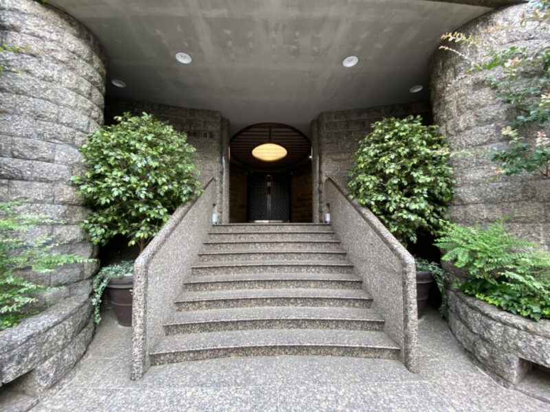 【エントランス】落ち着いた街並みに調和する、上品な雰囲気が魅力のエントランスです。建物全体の重厚感と調和した佇まいが、白金台の邸宅街にふさわしい品格を感じさせます。