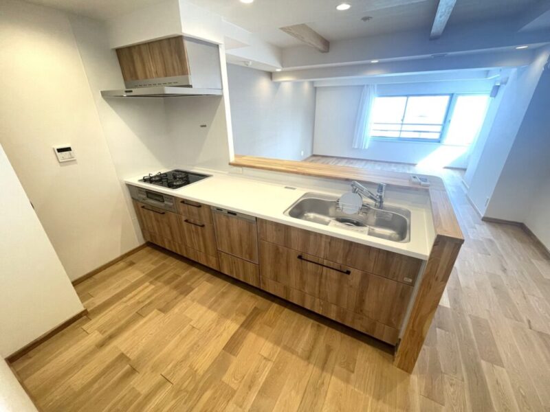 【キッチン:弊社施工事例】洗練されたデザインのキッチンは、ダイニングやリビングが見渡せ、コンロ側には壁があり、油跳ねもしにくいセミオープンキッチンです。お手入れしやすいレンジフードや3口コンロ、ビルトイン食器洗浄乾燥機付きで家事の負担軽減が期待できます。