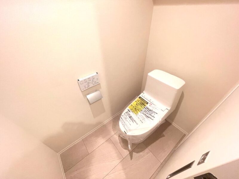 【トイレ】すっきりとしたデザインで清潔感があり、落ち着ける空間。トイレは温水洗浄機能付きです。吊戸棚も設置されており、トイレットペーパーなどが収納できます。