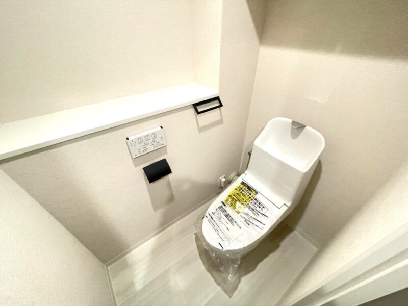 【トイレ】すっきりとしたデザインで清潔感があり、落ち着ける空間。トイレは温水洗浄機能付きです。吊戸棚も設置されており、トイレットペーパーなどが収納できます。
