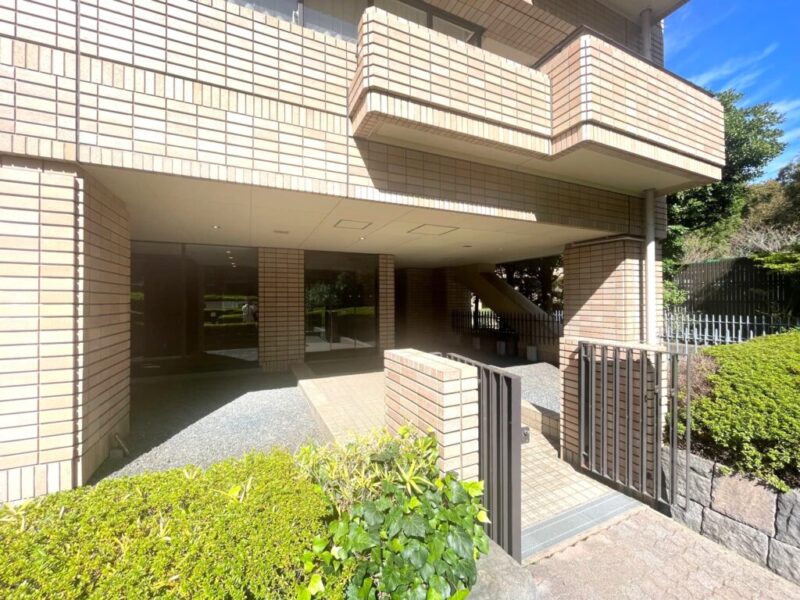 【エントランス】緑豊かな敷地の中に設けられたエントランスが、住まいへと続くアプローチに落ち着きをもたらします。都心にありながら自然の潤いを感じられる、広尾ガーデンヒルズならではの住環境が魅力です。セキュリティに配慮した管理体制に加え、オートロックなどの設備を備え、住まう方の安心をサポートします。