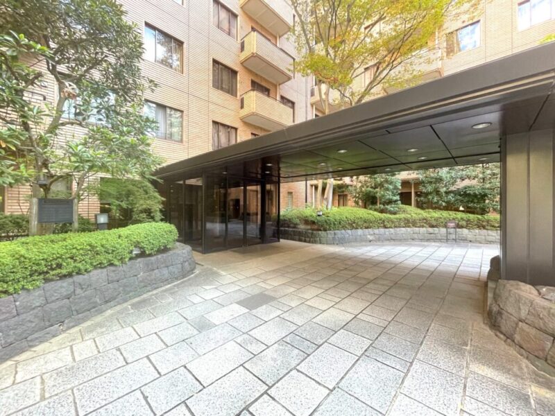 【エントランス】緑豊かな敷地の中に設けられた重厚で洗練されたエントランスが、住まいへと続くアプローチに落ち着きをもたらします。都心にありながら自然の潤いを感じられる、広尾ガーデンヒルズならではの住環境が魅力です。セキュリティに配慮した管理体制に加え、オートロックなどの設備を備え、住まう方の安心をサポートします。