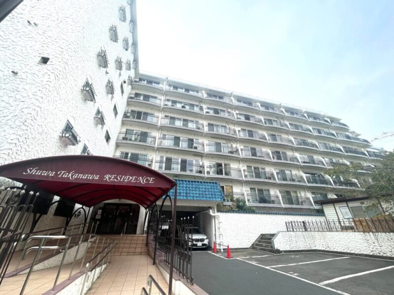 【外観】白いスタッコ調の壁面と青い瓦屋根が目を引く、秀和シリーズならではのヴィンテージマンションです。欧風の意匠と落ち着いた佇まいが、時を重ねても色あせない魅力を演出します。複数路線を使い分けられる、交通利便性の高い立地です。「泉岳寺」駅から都心各所へスムーズにアクセスでき、「高輪ゲートウェイ」駅や「白金高輪」駅も徒歩圏内。通勤・通学から休日のお出かけまで、軽快なフットワークを支えます。徒歩圏内に日常の買い物を支える店舗が点在し、忙しい毎日をサポートします。「白金高輪」駅周辺の商業施設や飲食店も利用しやすく、仕事帰りの買い物や休日の食事も気軽に楽しめます。周辺には区立小・中学校も徒歩10分前後に位置し、子育て世帯にも検討しやすい環境です。「JCHO東京高輪病院」などの医療機関も利用でき、日々の安心を支える生活基盤が整っています。歴史ある街並みと都心の利便性を享受できるロケーションで、穏やかな住環境とアクティブな都市生活を両立できます。