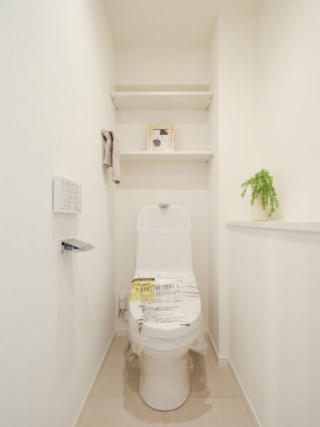 【トイレ】すっきりとしたデザインで清潔感があり、落ち着ける空間。トイレは温水洗浄機能付きです。吊棚やカウンターも設置されており、トイレットペーパーなどが収納できます。