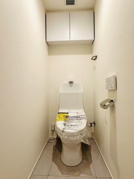 【トイレ】すっきりとしたデザインで清潔感があり、落ち着ける空間。トイレは温水洗浄機能付きです。吊戸棚も設置されており、トイレットペーパーなどが収納できます。