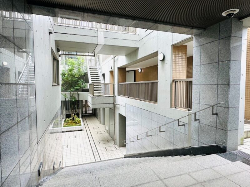 【エントランス】外壁の質感と直線的な建築デザインが調和する、落ち着いた佇まいのエントランス。建物の形状を生かしたアプローチが住まいへの期待感を高め、帰宅するたびに穏やかな気持ちをもたらします。オートロックシステムを採用し、住まう方の安心に配慮したセキュリティ体制です。宅配ロッカーも備え、外出中の荷物の受け取りにも便利。都心での快適な暮らしをサポートします。共有部にはゲストルームを備え、ご家族や友人が宿泊することもできます。